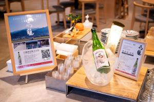 a table with two signs and a bottle of wine at REF Matsuyama City Station by VESSEL HOTELS in Matsuyama