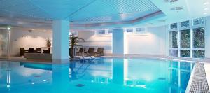 a swimming pool in a building with blue ceilings at Crowne Plaza Düsseldorf - Neuss by IHG in Neuss
