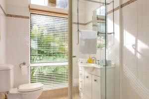 a bathroom with a toilet and a glass shower at Escape To Narrabeen @ Sydney Northern Beaches - Home Away From Home in Narrabeen +28 photos