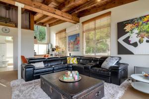 a living room with a leather couch and a table at Escape To Narrabeen @ Sydney Northern Beaches - Home Away From Home in Narrabeen