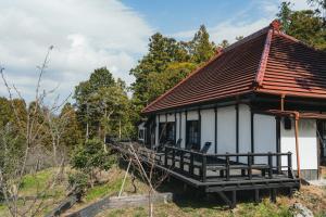 een klein huis met een veranda op een heuvel bij Kamogawa919 in Kamogawa