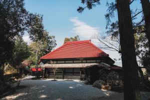 een gebouw met een rood dak in een bos bij Kamogawa919 in Kamogawa +16 foto's