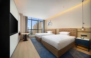 成都市にあるFour Points by Sheraton Chengdu, High-Tech Zone Exhibition Centerのベッド2台、薄型テレビが備わるホテルルームです。
