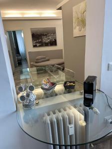 uma mesa de vidro numa sala de estar com um quarto com um sofá em BONBON em Rovigo