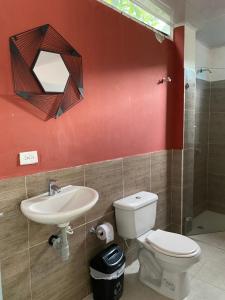 een badkamer met een toilet, een wastafel en een spiegel bij Eco Hostal La Perla Tayrona in El Zaino