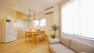 a living room with a couch and a table and a kitchen at TOKYO AKATSUKI HOTEL in Tokyo