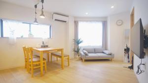 a living room with a table and chairs and a couch at TOKYO AKATSUKI HOTEL in Tokyo