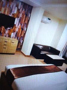 a bedroom with a bed and a dresser and a television at Villa toscana okpanam Rd Asaba in Okpanam
