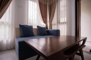 a living room with a blue couch and a table at Fresh Inn in Probolinggo