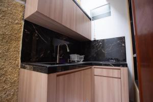 a kitchen with a sink and black counter top at Fresh Inn in Probolinggo +14 photos