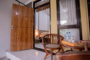 a dining room with a table and a wooden door at Fresh Inn in Probolinggo
