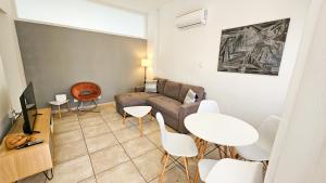sala de estar con sofá, mesa y sillas en FlipFlop City Center Apartment, en Lárnaca