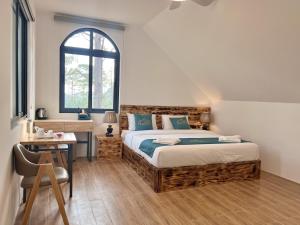 a bedroom with a bed and a desk and a window at Zephyrus Villa - Standard 1 in Kon Von Kla