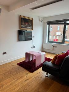 sala de estar con mesa rosa y sofá en Paradise - Away - From - Home en Bracknell