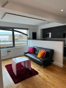 sala de estar con sofá negro y mesa en Paradise - Away - From - Home en Bracknell