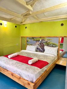 a bedroom with a large bed with a painting on the wall at Tree house in Ngong