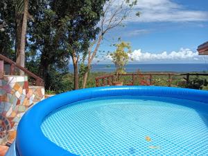a blue swimming pool with a view of the ocean at House On the Hill Overlooking in Mambajao
