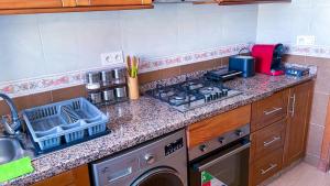 um balcão de cozinha com um fogão e um lavatório em Elite Holiday Home - Luxury & Centric Flat em Tânger