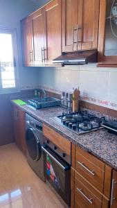 een keuken met een fornuis en een wasmachine bij Elite Holiday Home - Luxury & Centric Flat in Tanger