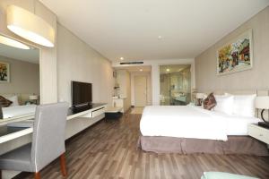 ein Hotelzimmer mit einem großen Bett und einem Schreibtisch in der Unterkunft Central Hotel Thanh Hoa in Thanh Hóa
