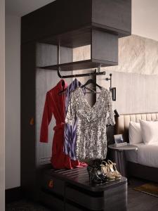 um quarto com uma cama e uma cómoda com roupas e sapatos em The Motley Hotel em Melbourne