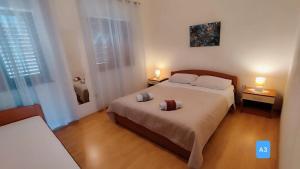 a bedroom with a large bed and two lamps at Apartments Josef - sea view in Veli Rat