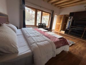 - un grand lit dans une chambre avec une grande fenêtre dans l'établissement Hillside homestay, à Leh