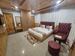 a large bedroom with a bed and a chair at Hotel Old Manali with Balcony and Mountain Views, Near Manali Mall Road in Manāli