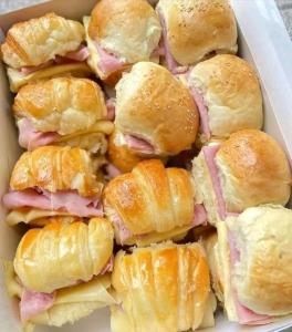 una scatola piena di panini con prosciutto e formaggio di Nails spa niño roberts a Quito