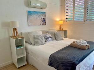 1 dormitorio con 1 cama blanca grande con almohadas en Bayona 1 Little Cove en Noosa Heads