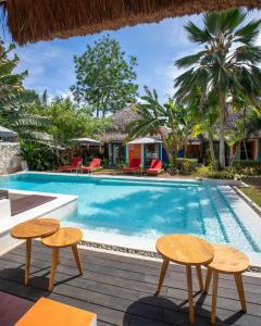 a pool with two tables and chairs next to a house at Villa Kasadya in Panglao