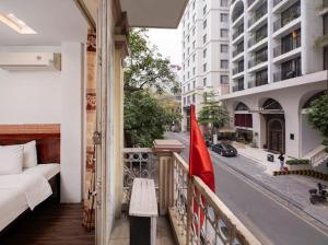 uma varanda com uma cama e uma bandeira numa rua em Hanoi Rose Flower Hotel & Spa em Hanói