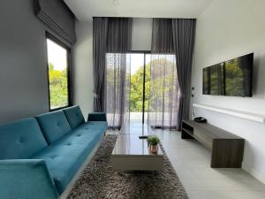un salon avec un canapé bleu et une table dans l'établissement Utopia Naiharn by Fred&Com Phuket, à Rawai Beach