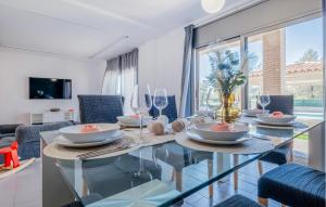 una sala da pranzo con un tavolo di vetro e sedie blu di Pet Friendly Home In Cabra Del Camp ad Aiguamurcia