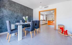una sala da pranzo con un tavolo e sedie blu di Pet Friendly Home In Cabra Del Camp ad Aiguamurcia
