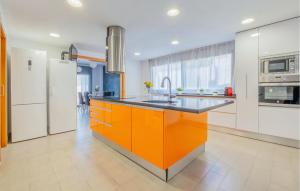 una cucina arancione e bianca con lavello e frigorifero di Pet Friendly Home In Cabra Del Camp ad Aiguamurcia