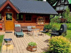 a patio with a table and chairs in front of a cabin at Apartmány Petronela in Makov