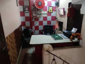um escritório com uma secretária e cadeiras num quarto em OYO Hotel AVS 8268 em Moradabad