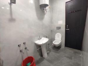 uma casa de banho com um WC branco e um lavatório. em OYO Hotel AVS 8268 em Moradabad