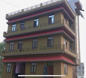 um edifício amarelo e vermelho alto com varandas em OYO Hotel AVS 8268 em Moradabad