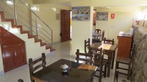 a dining room with two tables and a staircase at Hotel TIKA AYNA Cerca a la plaza de Armas CUSCO in Cusco