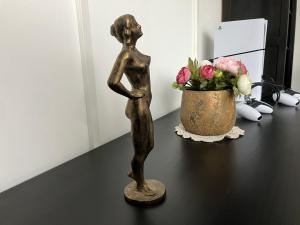uma estátua de bronze sobre uma mesa com um vaso de flores em MemoriaMarci - Free Bikes, Danube Band & Pilis em Pilismarót