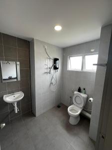 a bathroom with a toilet and a sink at Stay in Passionate in Sitiawan