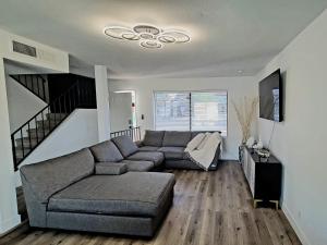 a living room with a gray couch and a staircase at Vegas best stay in Las Vegas