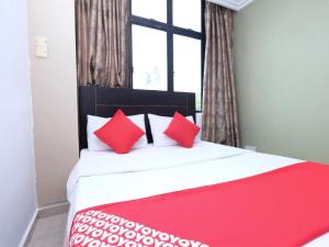 コタバルにあるMRJ Hotel Wakaf Che Yeh 2のベッドルーム1室(大型ベッド1台、赤い枕付)