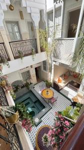 an indoor courtyard with a table and flowers on a balcony at Riad Magnolia & SPA in Marrakech