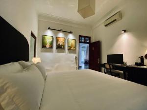 um quarto com uma grande cama branca e uma secretária em Viet Hai Lan Homestay em Ilha de Cát Bà