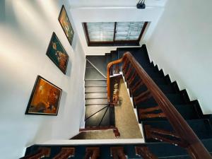 un escalier dans une maison ornée de peintures sur les murs dans l'établissement Viet Hai Lan Homestay, à Cat Ba