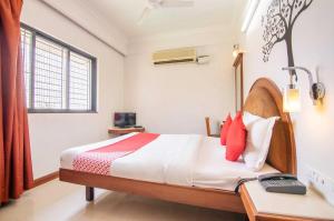 Schlafzimmer mit einem Bett und einem Fenster in der Unterkunft OYO Hotel Sunil Residency in Bangalore