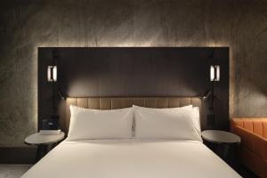 The Motley Hotel في ملبورن: غرفة نوم بسرير ابيض كبير مع طاولتين